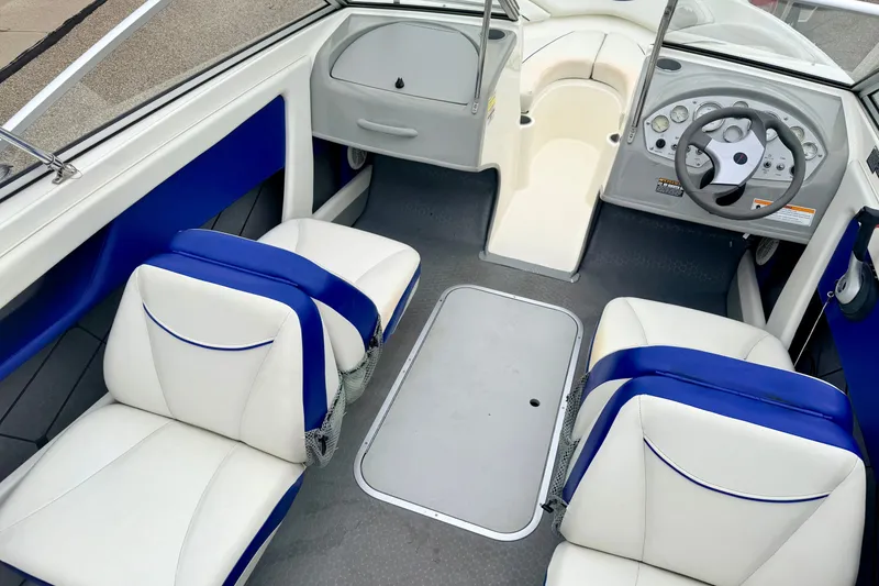 Slide: The Image of 2007 Bayliner 195 Discovery boat interior with blue and white seating and steering console. - 49