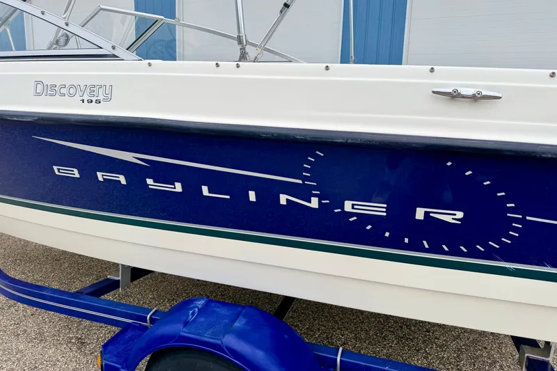 Slide: The Image of 2007 Bayliner 195 Discovery boat side view with blue and white design. - 9