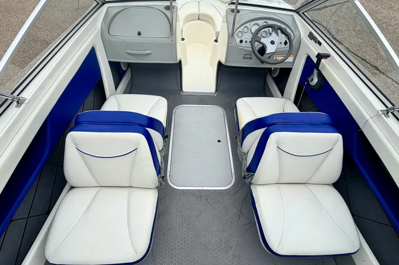 Slide: The Image of 2007 Bayliner 195 Discovery boat interior with white and blue seating, steering wheel, and dashboard. - 29