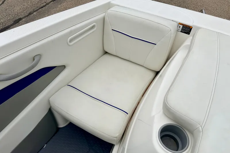 Slide: The Image of 2007 Bayliner 195 Discovery boat interior with white cushioned seating and cup holder. - 21