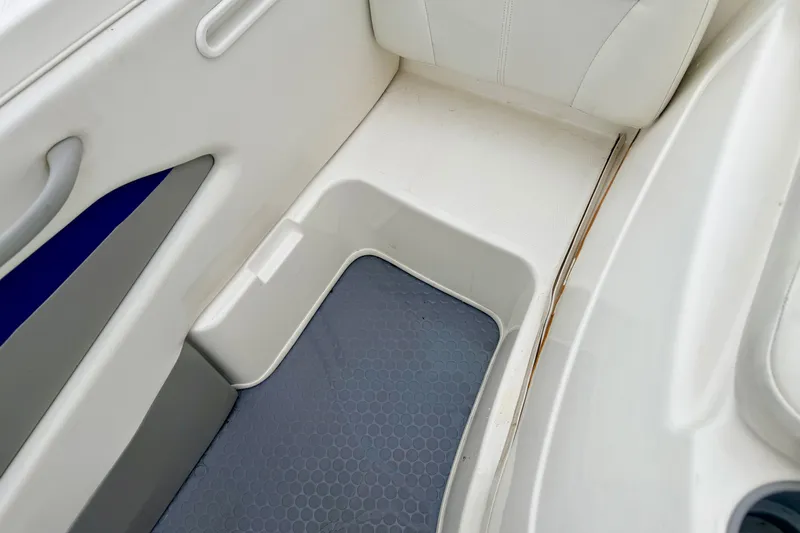 Slide: The Image of 2007 Bayliner 195 Discovery boat interior with white seating and gray flooring. - 23