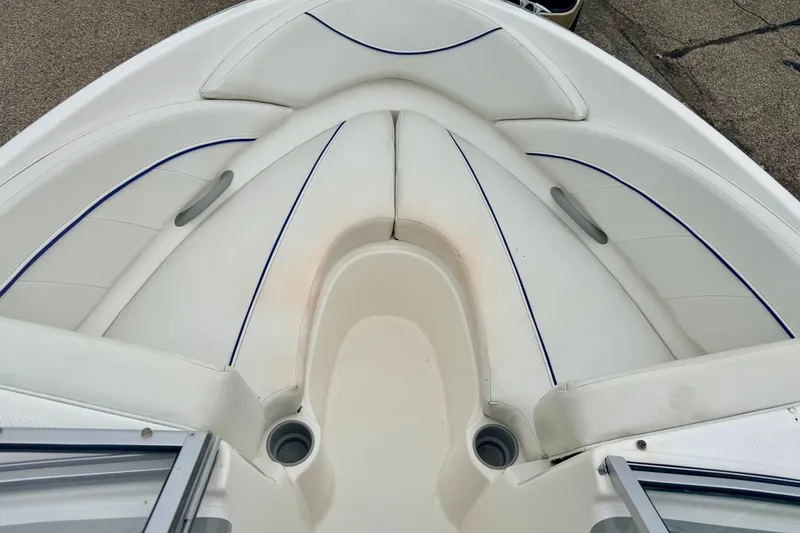 Slide: The Image of 2007 Bayliner 195 Discovery boat interior with white seating and blue accents. - 42