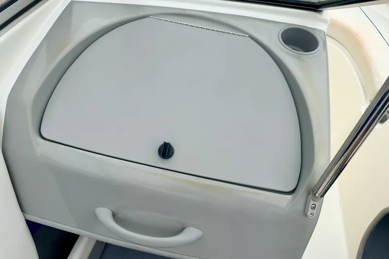 Slide: The Image of 2007 Bayliner 195 Discovery boat dashboard with storage compartment and cup holder. - 37