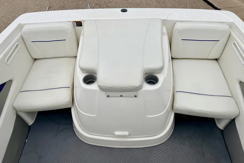 Slide: The Image of 2007 Bayliner 195 Discovery boat interior with white cushioned seating and cup holders. - 20