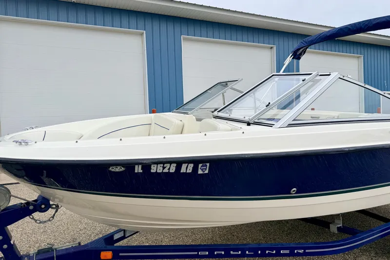 Slide: The Image of 2007 Bayliner 195 Discovery boat on trailer, parked near blue building. - 6