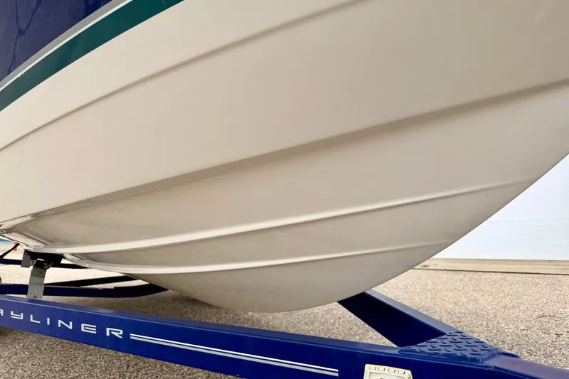 Slide: The Image of 2007 Bayliner 195 Discovery boat hull on a blue trailer, close-up view. - 52