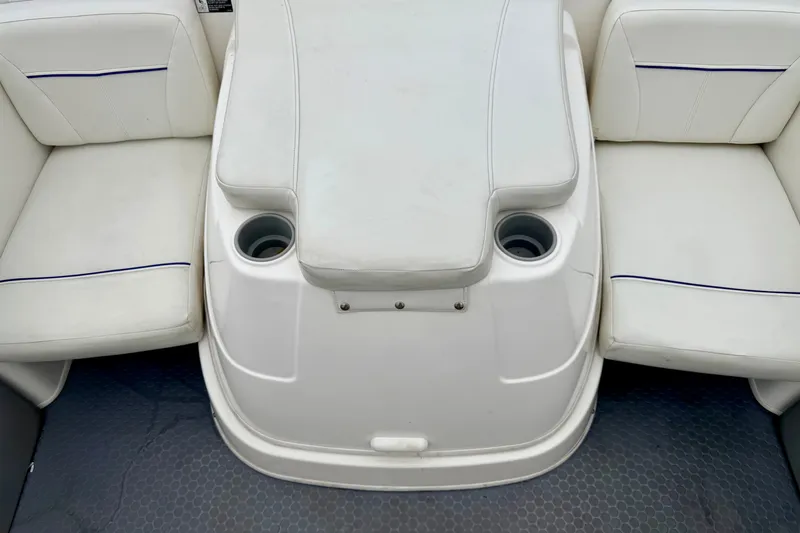 Slide: The Image of 2007 Bayliner 195 Discovery boat interior with white seating and cup holders. - 27