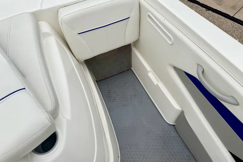 Slide: The Image of Interior of 2007 Bayliner 195 Discovery boat with white seating and blue accents. - 25