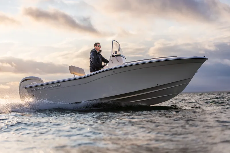 Slide: The Image of A 2027 Grady-White Fisherman 180 speeds across the water, piloted by a person. - 2
