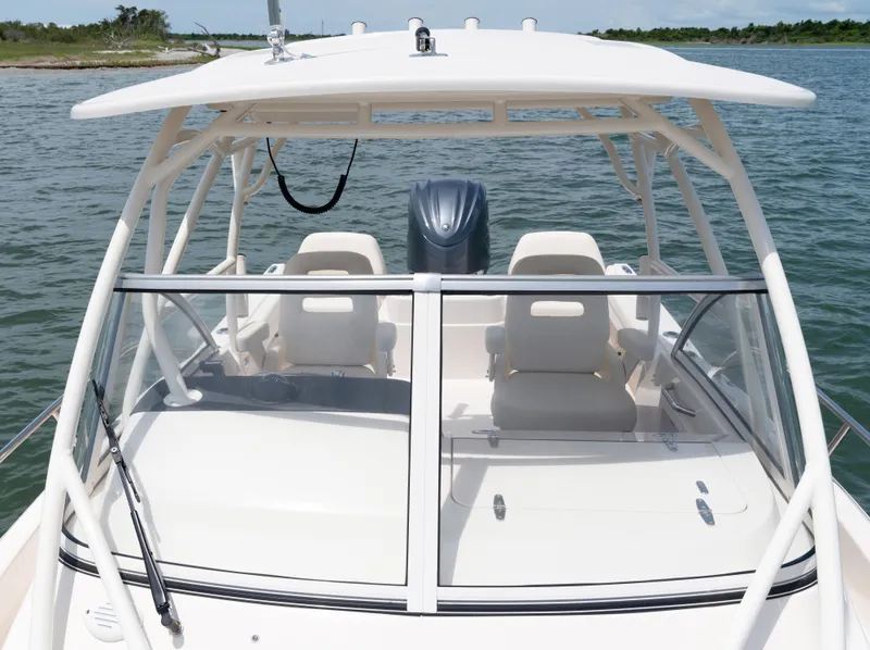 Slide: The Image of The image shows a Grady-White Adventure 218 boat on the water. It features a hardtop and two seats. - 2