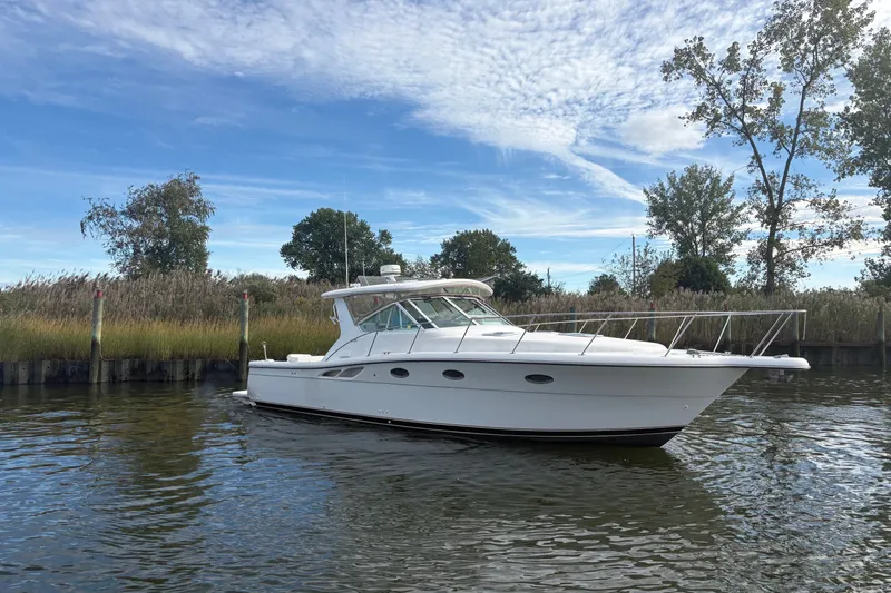 Slide: The Image of 2003 Tiara Yachts 3500 Open cruising on a serene waterway under a blue sky. - 4