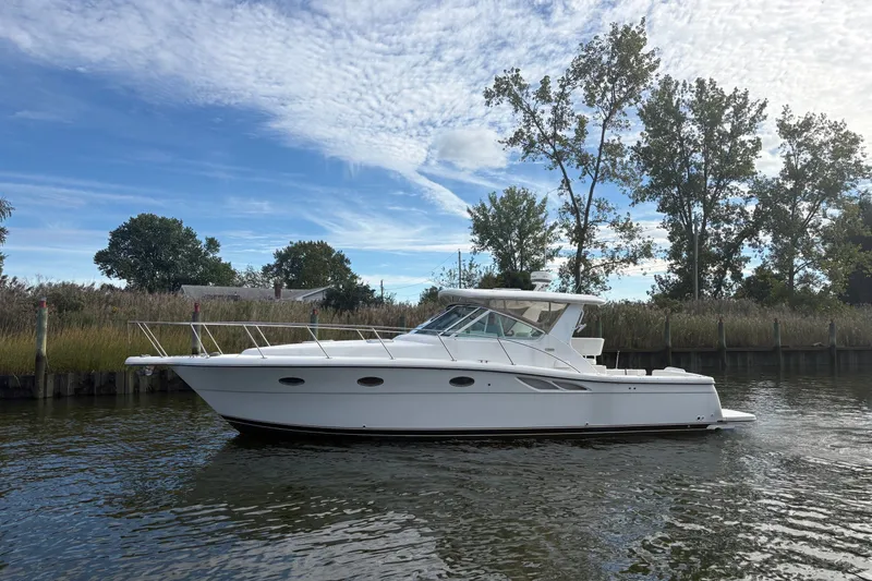 Slide: The Image of 2003 Tiara Yachts 3500 Open cruising on a calm river under a partly cloudy sky. - 0