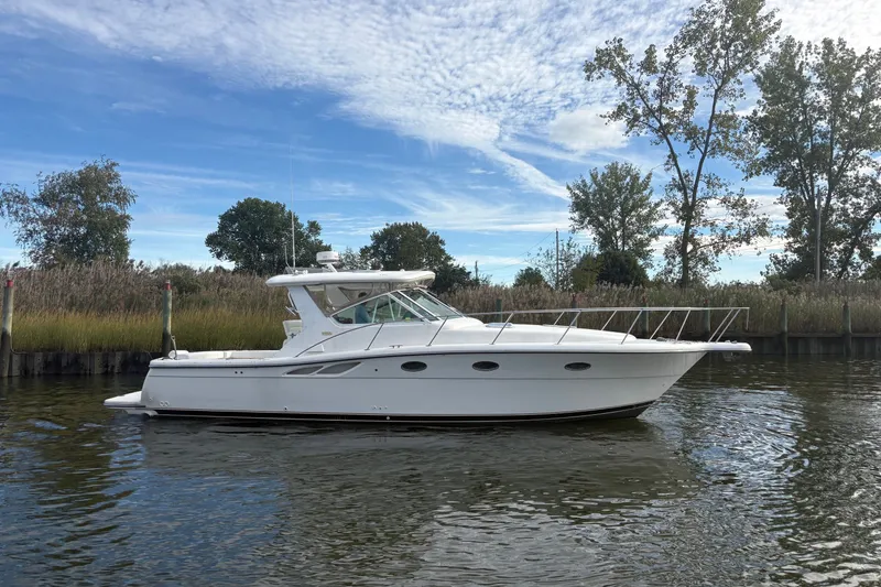 Slide: The Image of 2003 Tiara Yachts 3500 Open cruising on a calm river under a clear blue sky. - 3