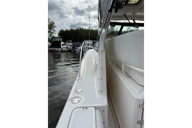 Slide: The Image of 2003 Tiara Yachts 3500 Open boat docked, showcasing sleek white deck and seating. - 8