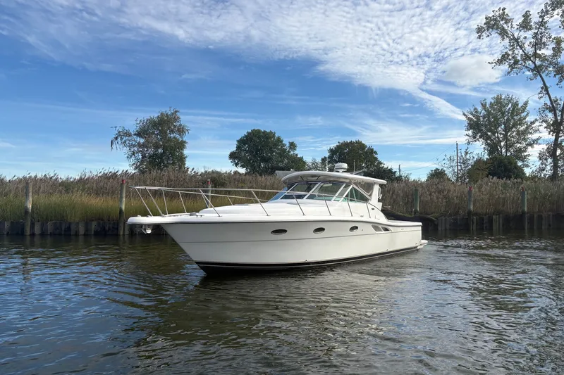 Slide: The Image of 2003 Tiara Yachts 3500 Open cruising on a calm river under a clear blue sky. - 2