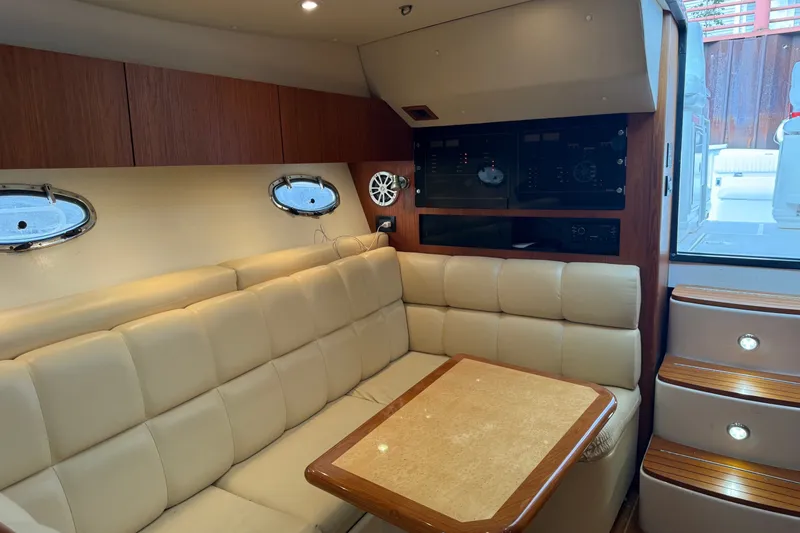 Slide: The Image of Interior of 2003 Tiara Yachts 3500 Open with beige seating and wooden accents. - 25