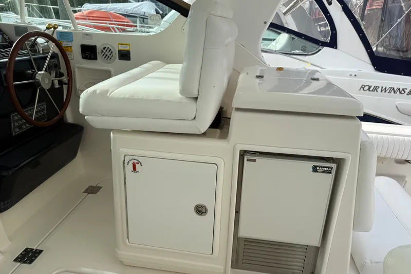 Slide: The Image of 2003 Tiara Yachts 3500 Open helm with white seating and steering wheel. - 14