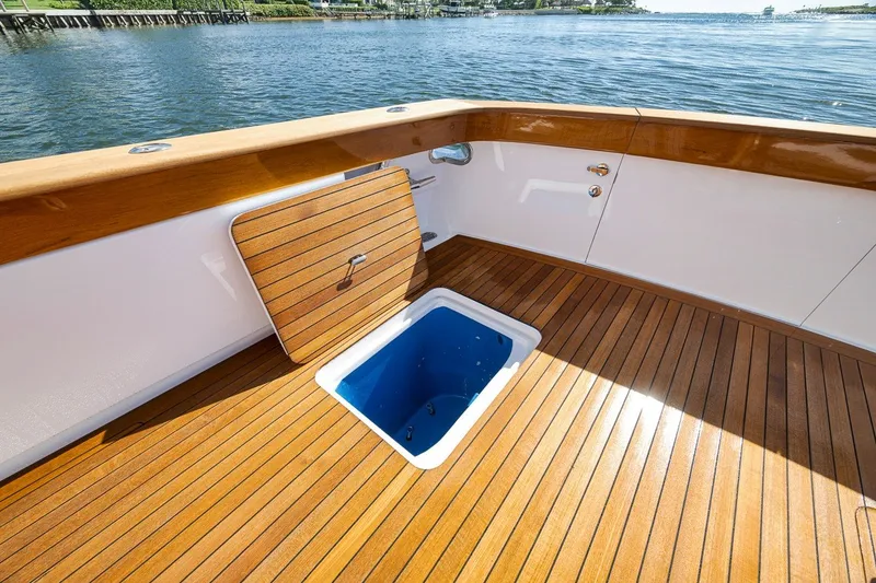 Slide: The Image of Teak deck of 1995 Merritt 65 Sport Fish boat with open hatch, overlooking water. - 21