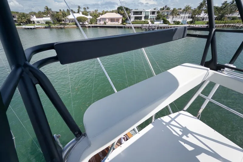 Slide: The Image of Merritt 65 Sport Fish yacht, 1995 model, overlooking serene waterfront homes. - 14