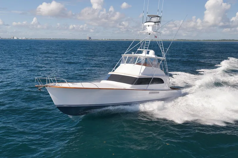 Slide: The Image of 1995 Merritt 65 Sport Fish yacht cruising on open ocean under clear skies. - 1