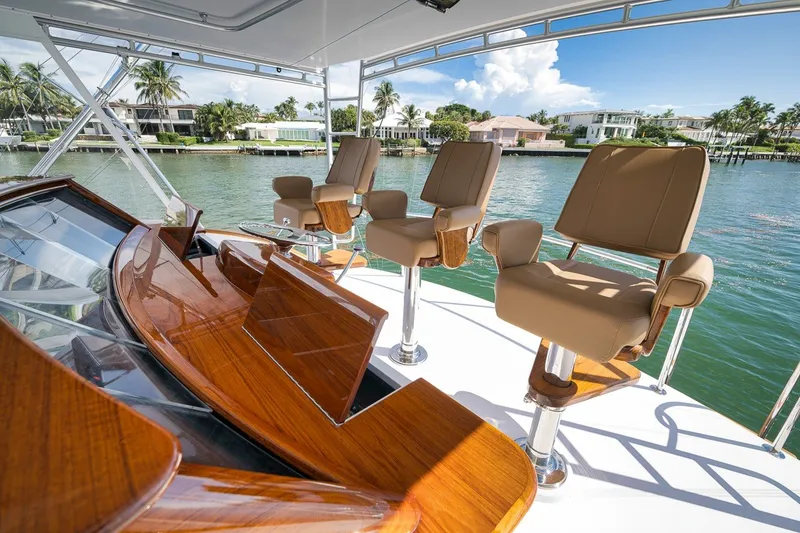Slide: The Image of Luxurious Merritt 65 Sport Fish yacht interior with elegant seating, overlooking serene waterfront homes. - 8