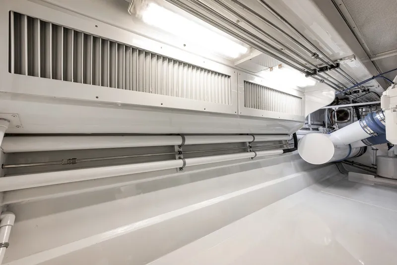 Slide: The Image of Engine room of 1995 Merritt 65 Sport Fish boat, showcasing clean, organized piping and ventilation. - 30