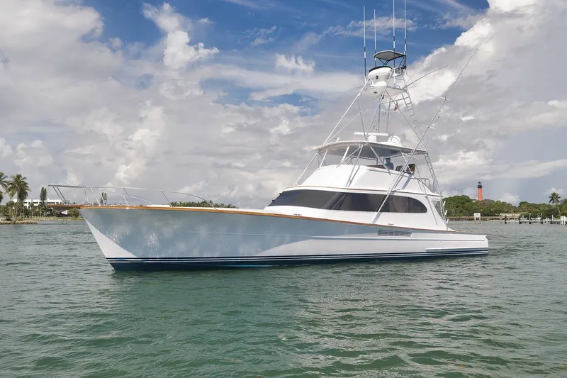 Slide: The Image of 1995 Merritt 65 Sport Fish yacht on calm waters under a partly cloudy sky. - 2