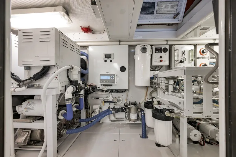 Slide: The Image of Engine room of a 1995 Merritt 65 Sport Fish boat, showcasing complex machinery and equipment. - 32