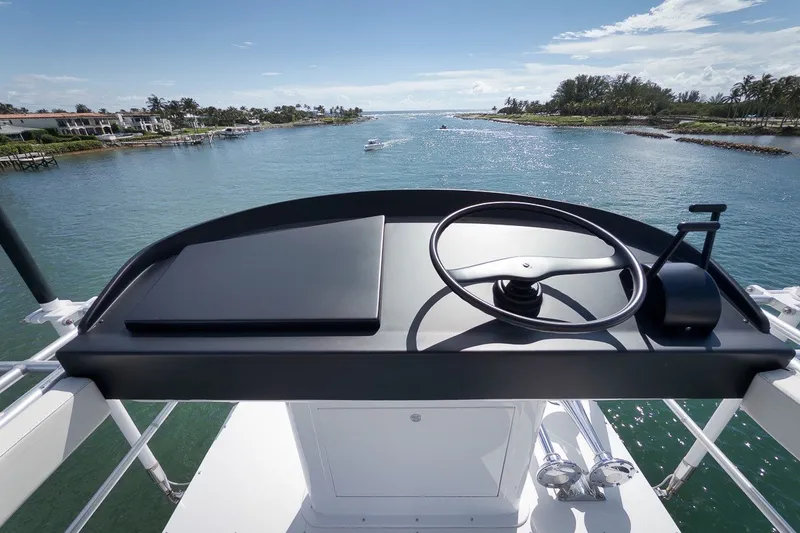 Slide: The Image of Helm of 1995 Merritt 65 Sport Fish yacht overlooking serene coastal waters. - 12