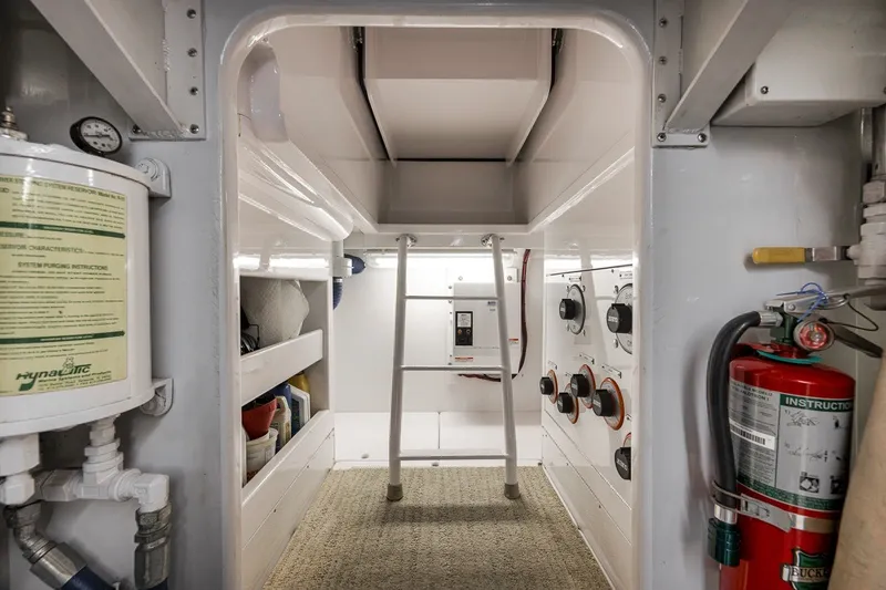 Slide: The Image of Engine room of 1995 Merritt 65 Sport Fish boat with equipment and fire extinguisher. - 25