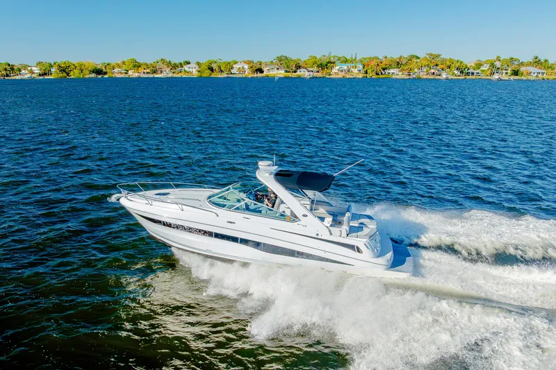 Slide: The Image of 2013 Sea Ray 370 Venture cruising on a sunny day, with scenic shoreline in the background. - 15