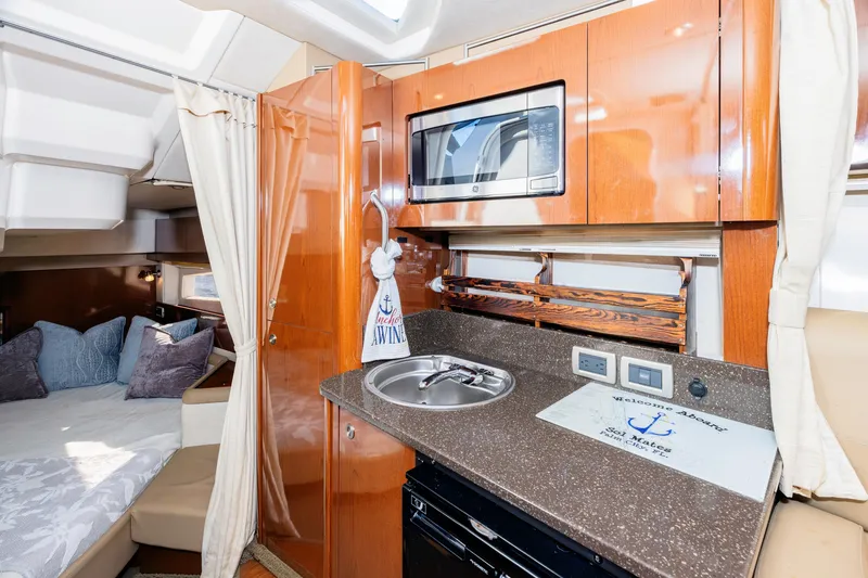 Slide: The Image of 2013 Sea Ray 370 Venture interior with kitchenette and cozy sleeping area. - 22