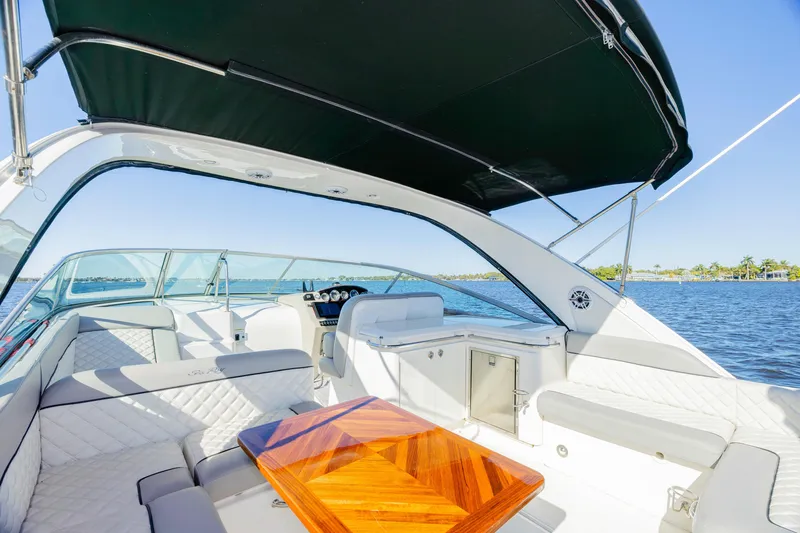 Slide: The Image of 2013 Sea Ray 370 Venture yacht interior with seating and table on a sunny day. - 3