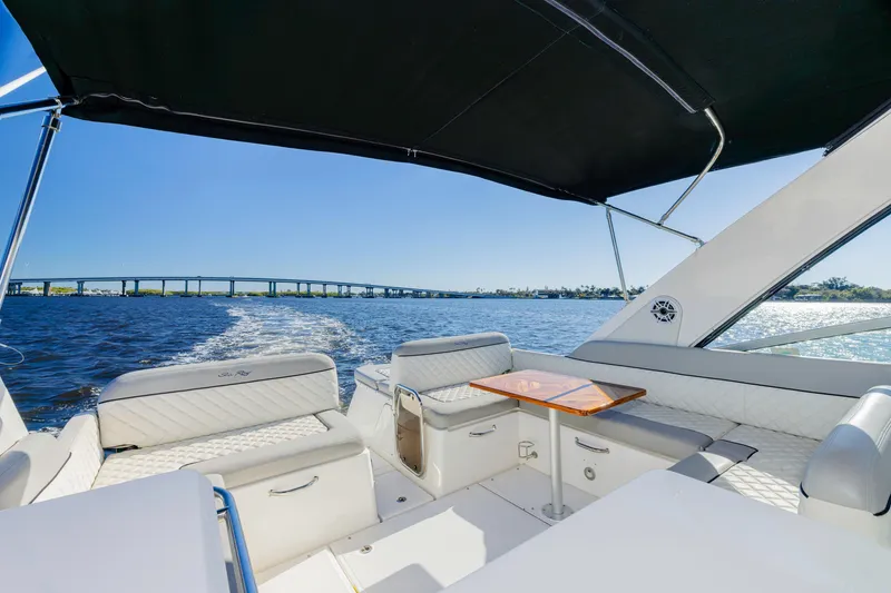 Slide: The Image of 2013 Sea Ray 370 Venture boat interior with seating, table, and ocean view. - 4
