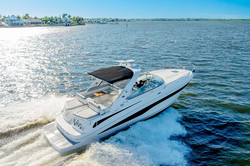 Slide: The Image of 2013 Sea Ray 370 Venture cruising on a sunny day, with coastal homes in the background. - 25