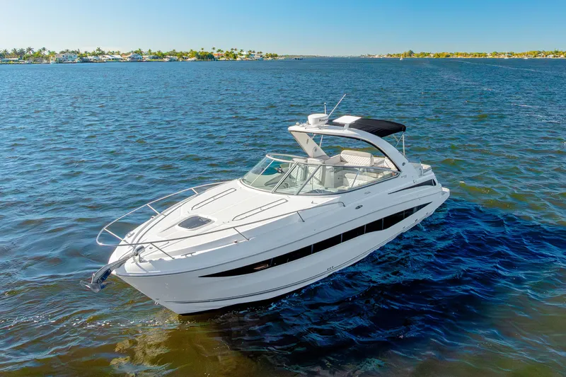 Slide: The Image of 2013 Sea Ray 370 Venture yacht cruising on open water under clear blue skies. - 27