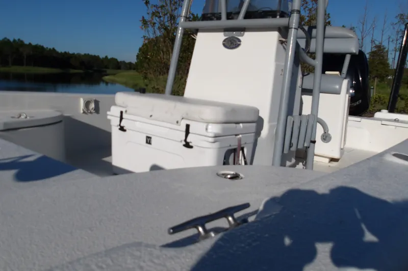 Slide: The Image of 2008 Ranger 2200 Bay Ranger boat interior with cooler and seating, near a serene lake. - 5