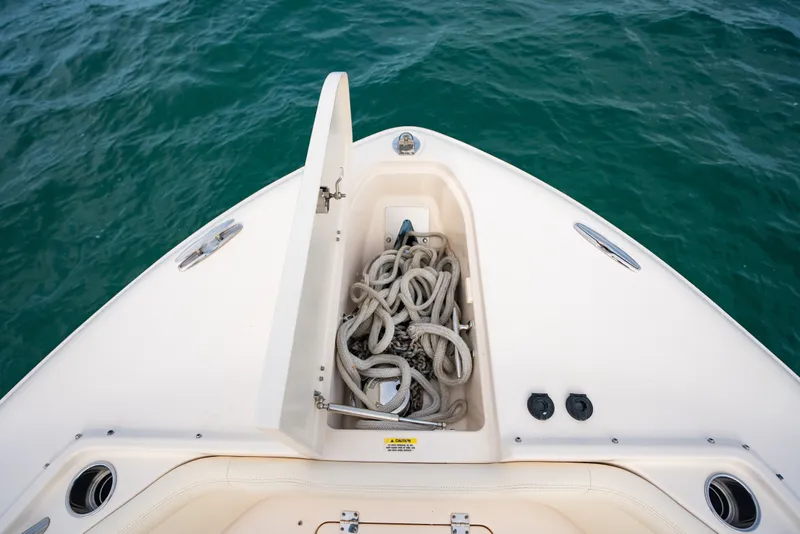 Slide: The Image of Bow storage compartment on 2015 Grady-White Freedom 335 boat with coiled rope. - 25