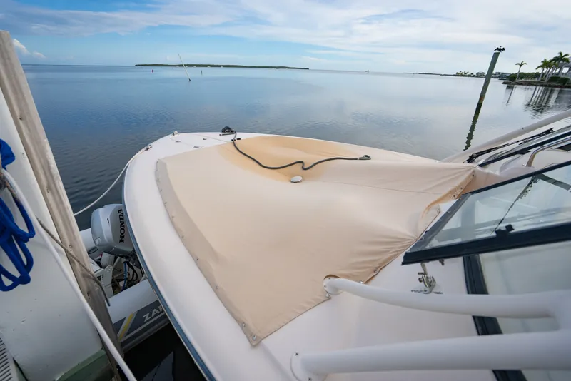 Slide: The Image of 2015 Grady-White Freedom 335 boat docked on calm water, featuring a covered bow area. - 17