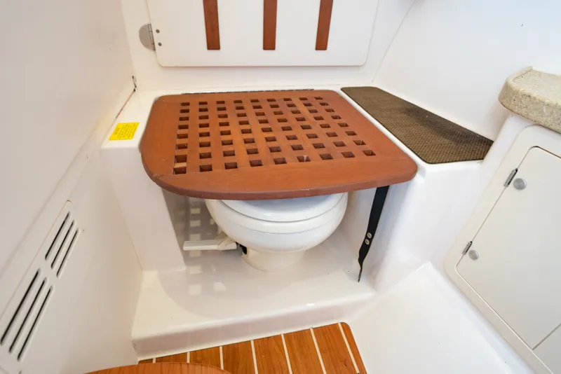 Slide: The Image of 2015 Grady-White Freedom 335 boat interior with wooden toilet cover. - 43