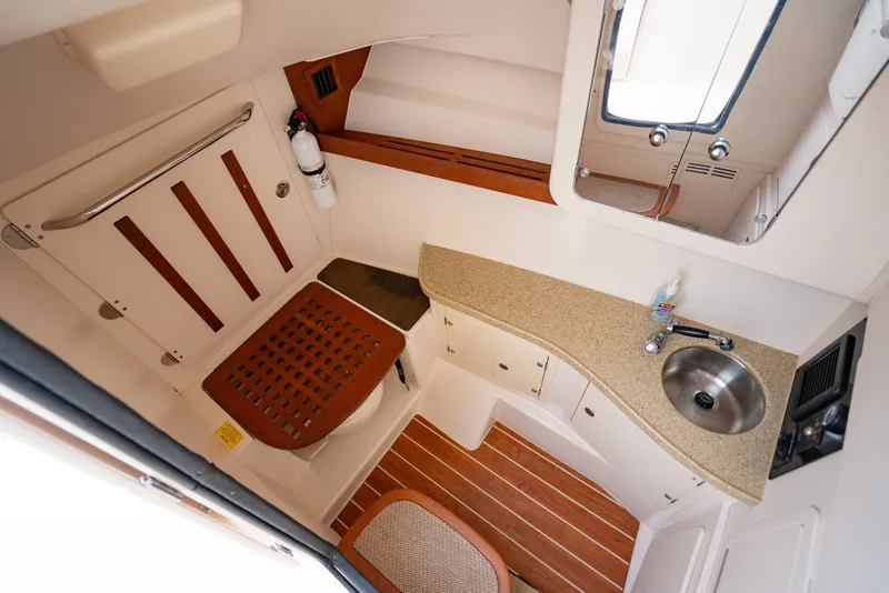 Slide: The Image of 2015 Grady-White Freedom 335 boat interior with sink, toilet, and wooden accents. - 40