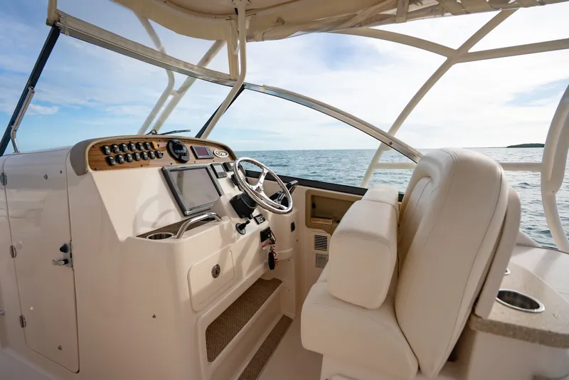 Slide: The Image of 2015 Grady-White Freedom 335 boat interior with steering wheel and ocean view. - 30