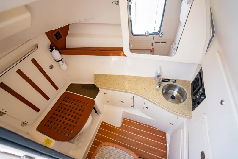 Slide: The Image of 2015 Grady-White Freedom 335 boat interior with sink, countertop, and wooden flooring. - 46