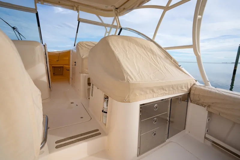 Slide: The Image of 2015 Grady-White Freedom 335 boat interior with covered seating and storage compartments. - 22