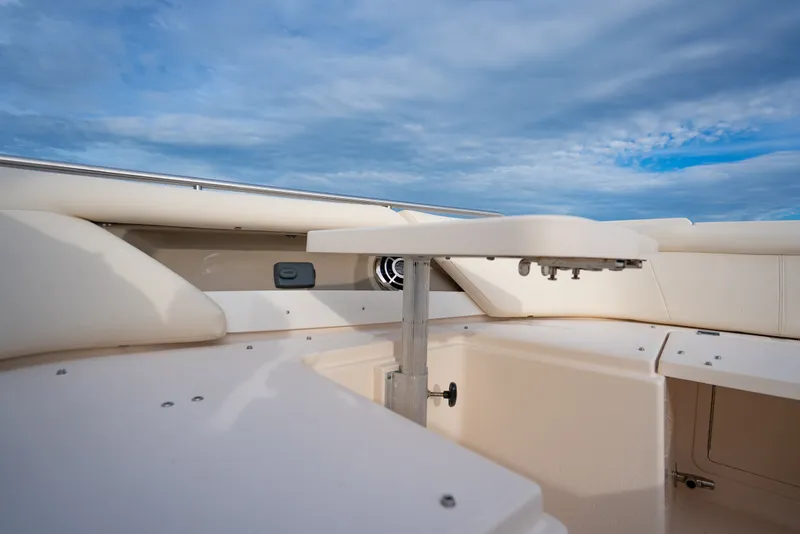 Slide: The Image of 2015 Grady-White Freedom 335 boat interior with seating and table under blue sky. - 28
