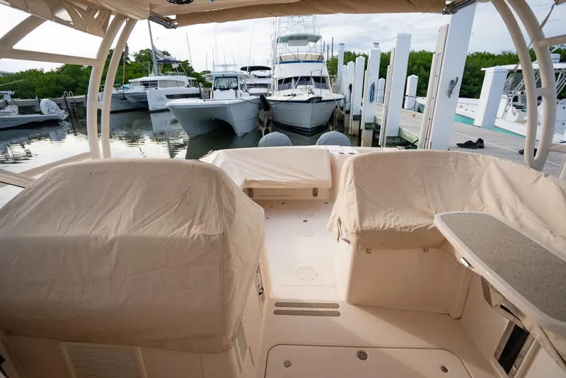 Slide: The Image of 2015 Grady-White Freedom 335 boat interior at marina, covered seats, docked vessels in background. - 21