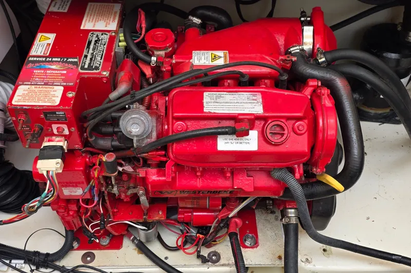 Slide: The Image of Red engine of a 2007 Boston Whaler 305 Conquest boat, featuring detailed wiring and components. - 54
