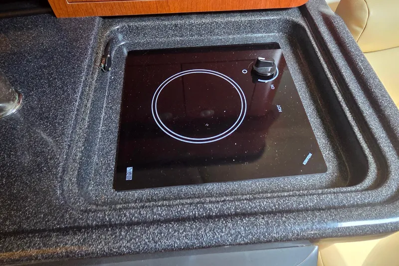 Slide: The Image of 2007 Boston Whaler 305 Conquest stovetop with sleek black surface and control knob. - 45