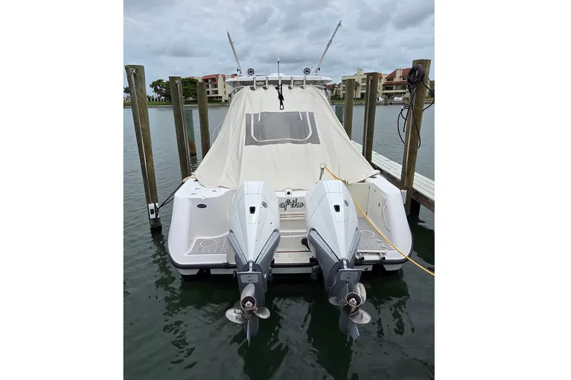 Slide: The Image of 2007 Boston Whaler 305 Conquest docked with twin outboard motors, covered and secured. - 58