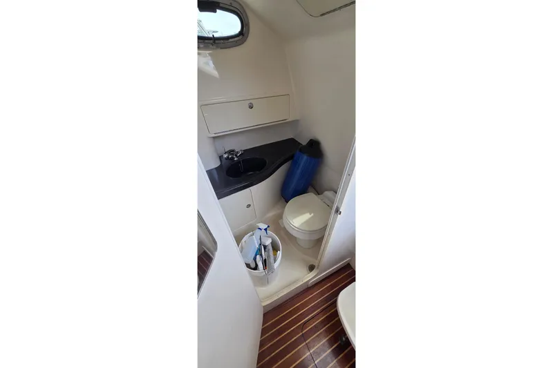 Slide: The Image of 2007 Boston Whaler 305 Conquest boat bathroom with sink, toilet, and storage. - 48